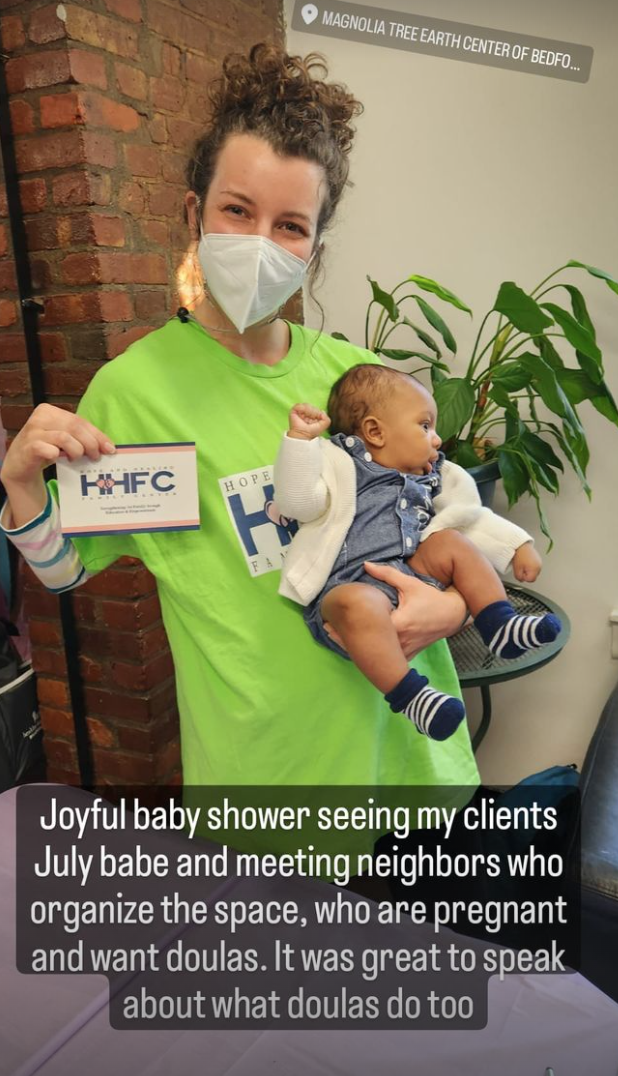 Bryen holding 3 month old client's baby at baby shower